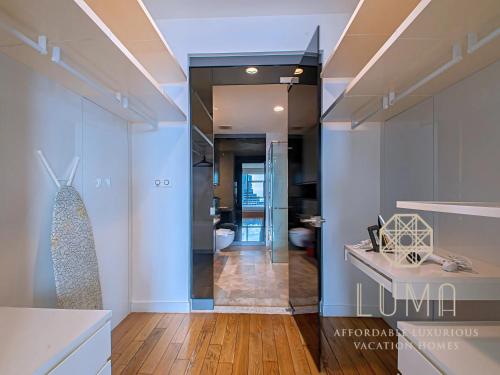 a kitchen with a glass door leading to a bathroom at The Platinum Kuala Lumpur by LUMA in Kuala Lumpur