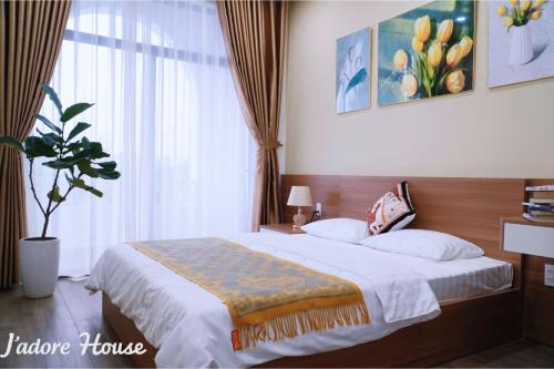 a bedroom with a bed and a large window at Jadore House in Danang