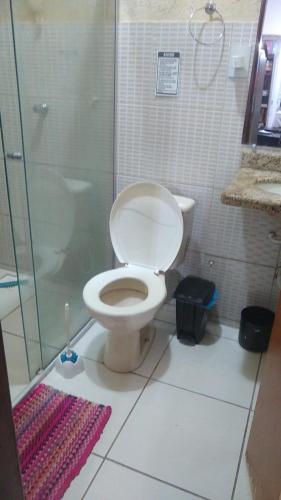 a bathroom with a toilet and a glass shower at Jams Hostel - Pousada em Catalão in Catalão