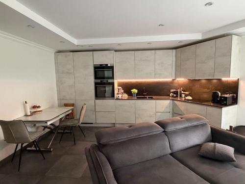 a living room with a couch and a table and a kitchen at Terraced apartment in Kayl