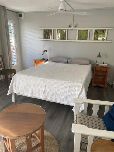 a bedroom with a bed and a table and chairs at Spacious basement studio in tranquil nook in Rivière Noire