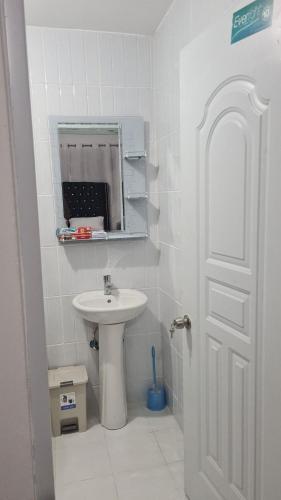 a white bathroom with a sink and a mirror at Apartment Ñ4 in La Grúa