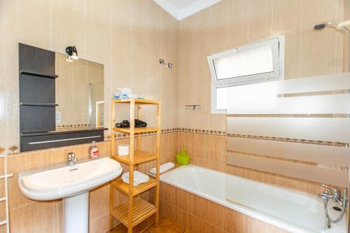 a bathroom with a sink and a tub and a mirror at Casa Verdejo in Cómpeta