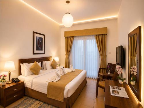 a hotel room with a bed and a desk at Tulip Hotel Apartments in Dubai