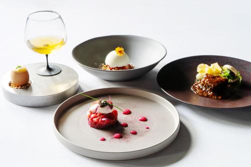 a table with plates of desserts and a glass of wine at KANAYA RESORT HAKONE in Hakone