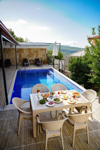 a patio with a table and chairs next to a pool at Comfy Villa Ipek with Pool in Kaş