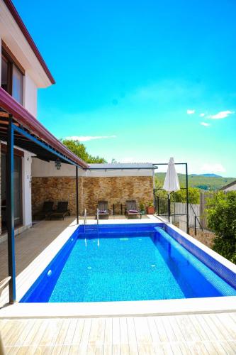 a swimming pool in the backyard of a house at Comfy Villa Ipek with Pool in Kaş