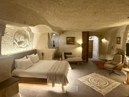 a bedroom with a bed and a chair in a room at Miras Hotel in Göreme