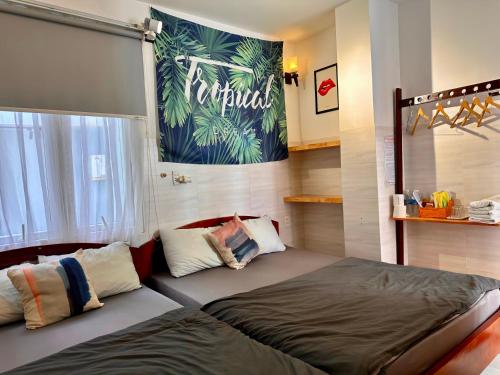 a bedroom with two beds and a poster on the wall at Lighthouse Homestay Vũng Tàu in Vung Tau