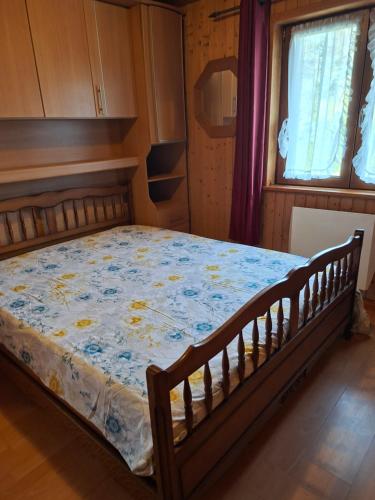 a bedroom with a bed with a blue and yellow comforter at Le Paradis du Chalet Perce-Neige in Châtel-Saint-Denis