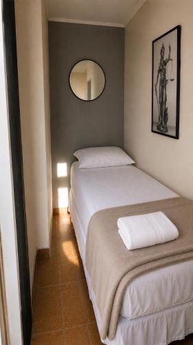 two beds in a small room with a mirror at Jams Hostel - Pousada em Catalão in Catalão