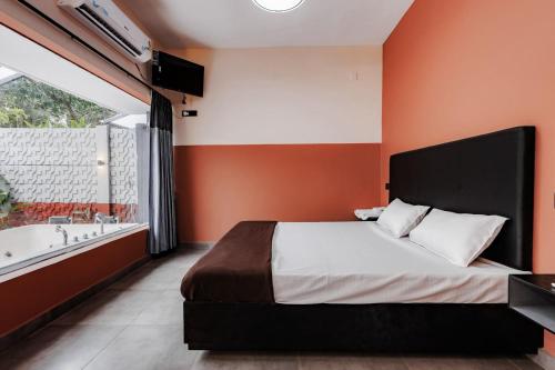 a bedroom with a large bed and a bath tub at Nitz the loft in Pondicherry