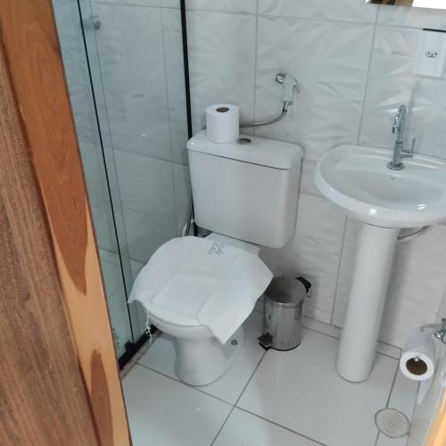 a white bathroom with a toilet and a sink at Pousada Mandala in Palmeiras