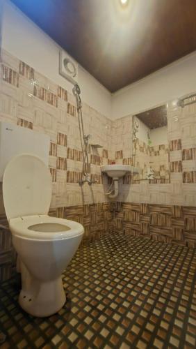 ein Badezimmer mit Toilette und Waschbecken in der Unterkunft Bambooleaf pool dormitory in Meppādi