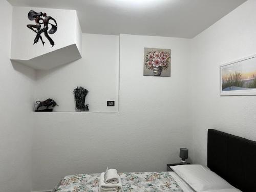 a bedroom with a bed and some pictures on the wall at "DOMUS LEONE" - Nel Borgo di Capri Leone in Capri Leone