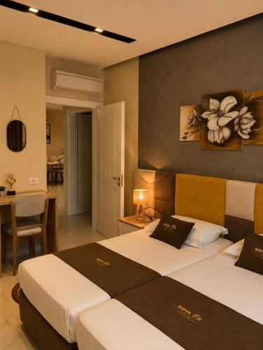 a hotel room with two beds and a dining room at Nova Apartaments Qerret ZL in Golem