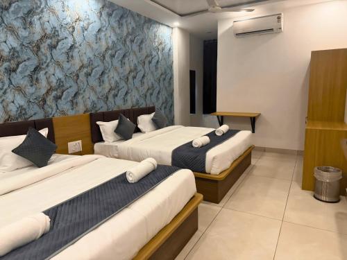 a hotel room with two beds and a wall mural at Sunburry Hotel Khatu 700mts from Temple in Khātu