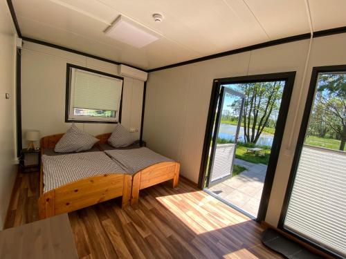 a room with a bed and a sliding glass door at Naturerlebnis-Schlafcontainer in Leutershausen