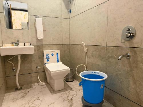 a bathroom with a toilet and a bucket in it at Sunburry Hotel Khatu 700mts from Temple in Khātu