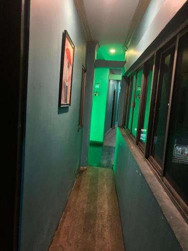 a hallway with green lights in a building at Blue Horizon hotel & restaurent in Nalbāri