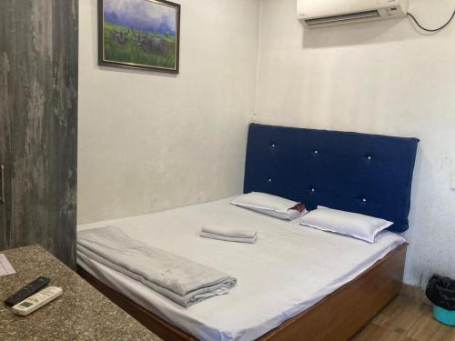 a bed with a blue headboard in a room at Blue Horizon hotel & restaurent in Nalbāri