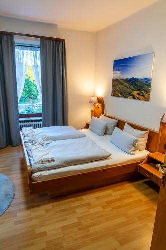 a bedroom with a large bed with a window at Hotel Restaurant St. Germanshof in Bobenthal