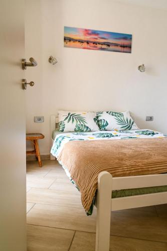 a bedroom with a bed and a painting on the wall at Apartman Darija 3 in Gornji Orahovac