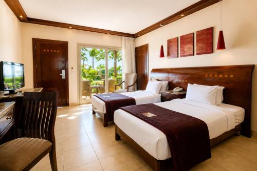 a hotel room with two beds and a television at Shams Prestige Abu Soma (Adults Only) in Hurghada