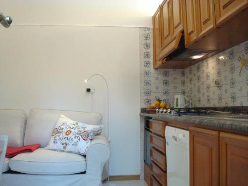 ein Wohnzimmer mit einem Stuhl und eine Küche in der Unterkunft Villino Caproni in Viareggio