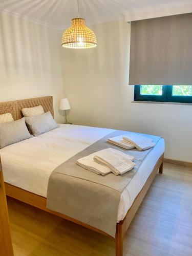 a bedroom with a bed with towels on it at Paraiso do Rio Casa T1 in Mondim de Basto