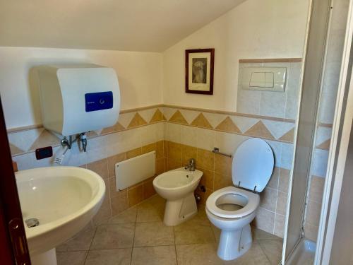 a bathroom with a toilet and a sink at AgroVerde Apartment a 10 minuti da Alghero in Tottubella