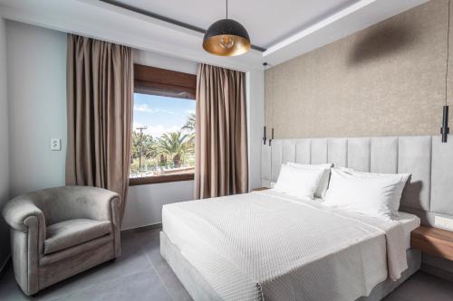 a bedroom with a bed and a chair and a window at Anna Maria Paradise in Pefkochori