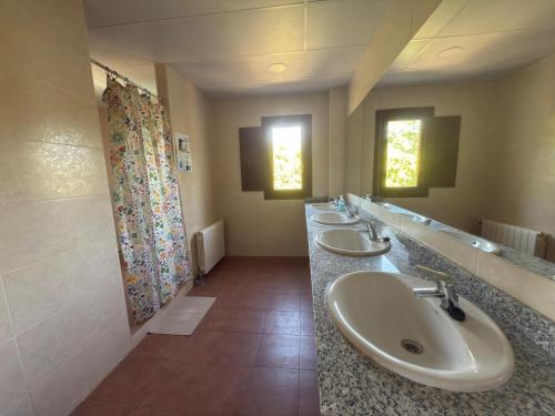 a bathroom with three sinks and a row of mirrors at Albergue Niu d'Estels in Albiol