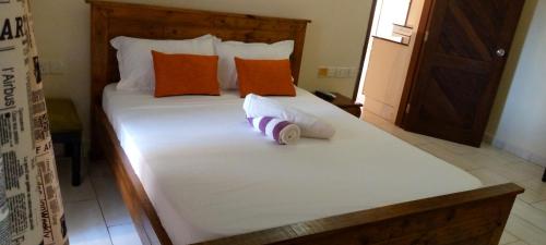 a white bed with orange and white pillows on it at Heaven place -1 bedroom beachfront unit in Ukunda