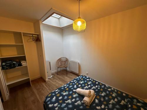 a bedroom with a bed and a chair in it at Palma Verde - centre ville - wifi in Niort