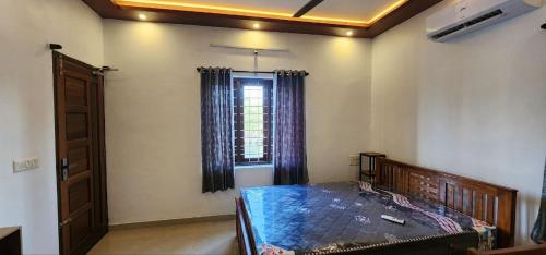 a bedroom with a bed and a window at Pearl's Lake House in Cochin