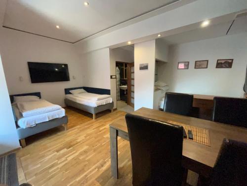a room with a table and a bed and a couch at Pokoje Gościnne Pocztacaffe in Gdynia