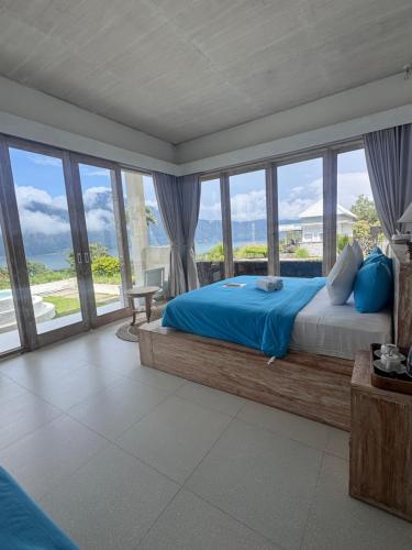 a bedroom with a bed and a large window at The Breezy Volcano in Kintamani
