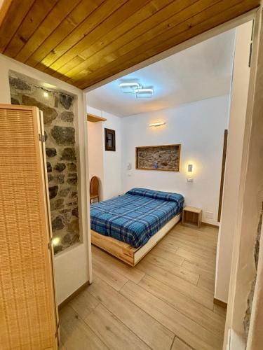 a bedroom with a bed and a stone wall at Appartamento Osnao in Cefalù
