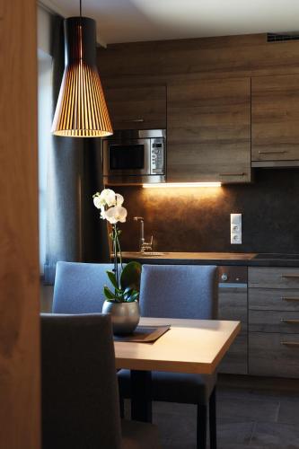 a kitchen with a table with a vase of flowers on it at Appartementhaus Sonnenhang in Ehrwald