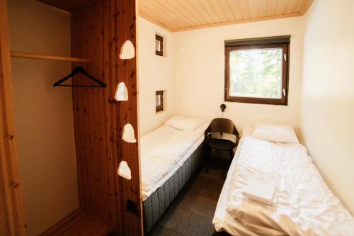 a small bedroom with two beds and a window at Käenpesän Aihki in Syöte