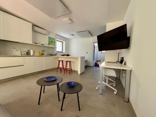 a kitchen with two stools and a table and a tv at Ankaran Studio Escape in Ankaran