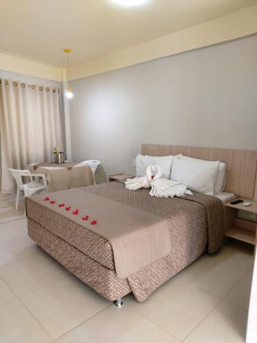 a bedroom with a large bed with towels on it at Lebanon Praia Hotel in Tramandaí