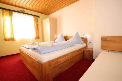 a bedroom with a wooden bed with a window at Haus Sonnenterrasse in Sankt Veit im Pongau