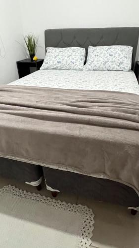 a bedroom with a large bed with white sheets at Apartamento Completo No Centro de Taboão da Serra in Taboão da Serra
