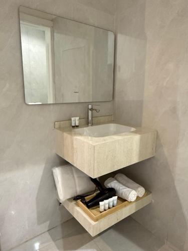 a bathroom with a sink and a mirror and towels at أجنحة السمو in Hail