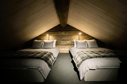 two beds in a room with a attic at Log cabin in Hodlekve with mountain view in Sogndal