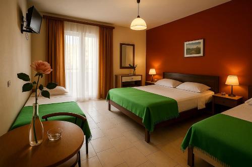 a hotel room with two beds and a table at Hotel Dias Apartment in Makrygialos