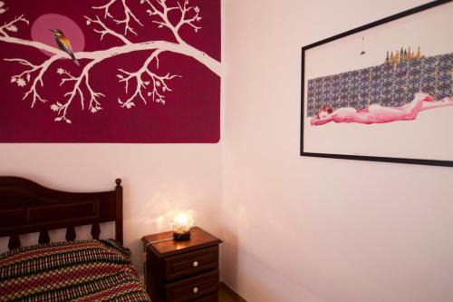 a bedroom with a bed and a picture on the wall at Hostel Seixe in Odeceixe