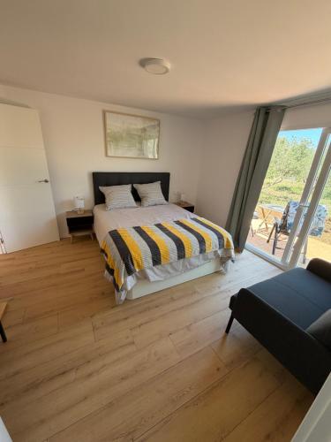 a bedroom with a bed and a large window at Tossal del Pla in Estivella